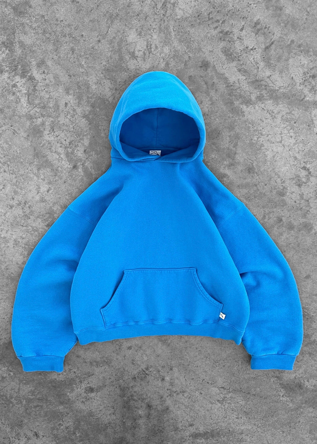 Comfortabele unisex hoodie in crème wit, essentieel voor ontspannen momenten.