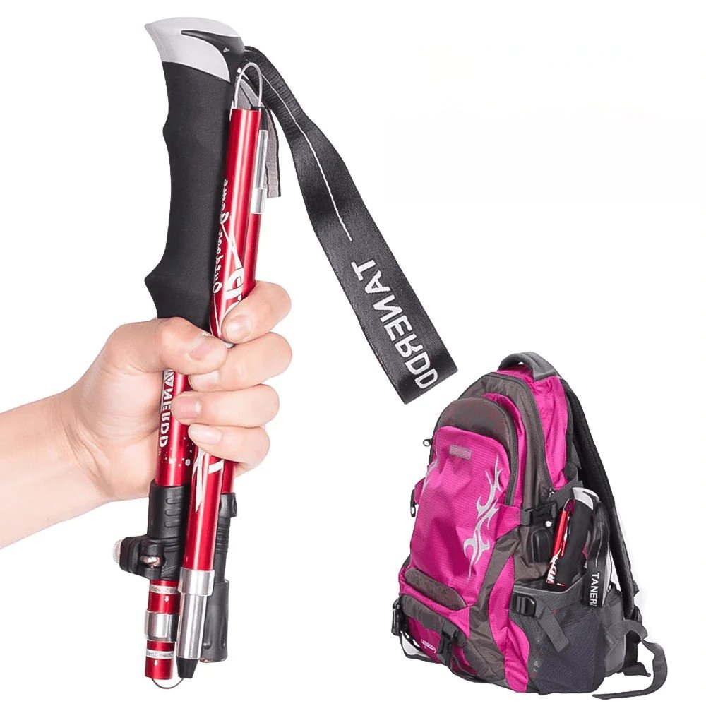 Compacte rode wandelstok in de hand naast een reistas