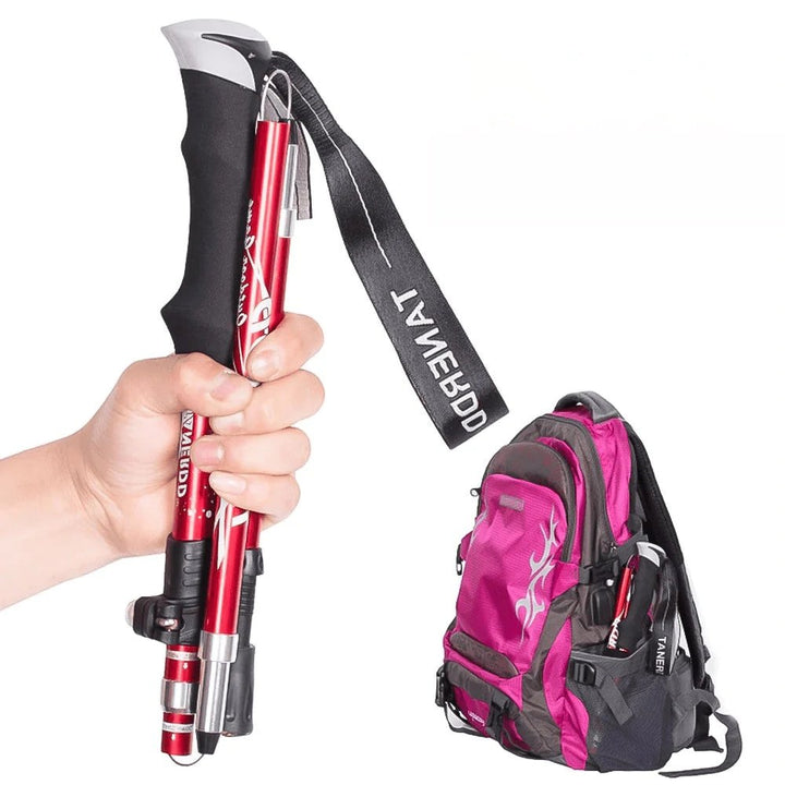 Compacte rode wandelstok in de hand naast een reistas