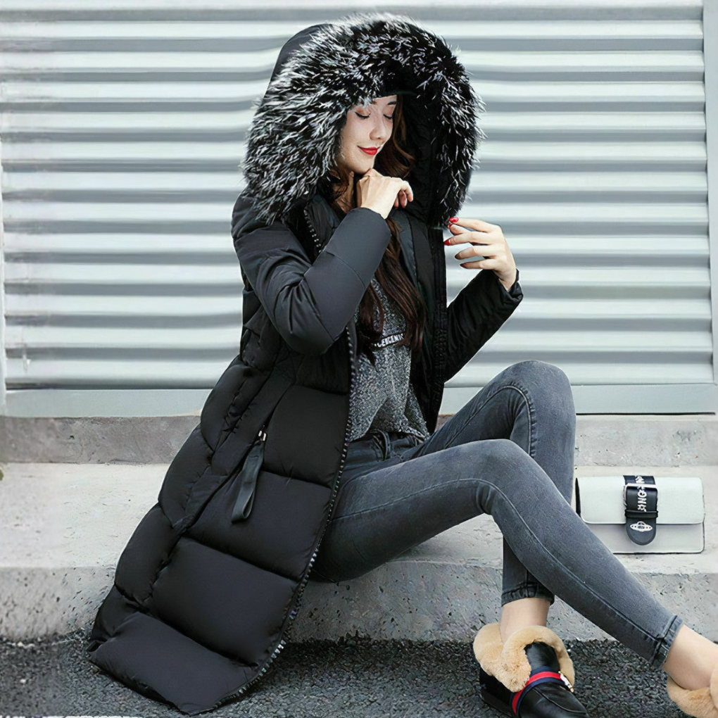 Model draagt luxe lange dames winterjas met volle bontkraag. Perfecte warme outwear voor koud weer.