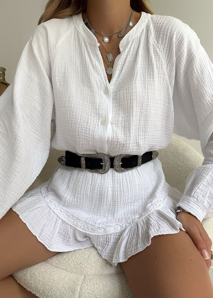 Modieuze witte damesset Leora met comfortabele blouse en speelse ruffle short, perfect voor een chique zomeroutfit.