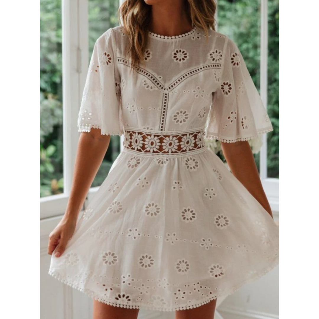 Witte luchtige zomerjurk voor dames met elegante details en kanten accenten, ideaal voor casual of feestelijke gelegenheden.