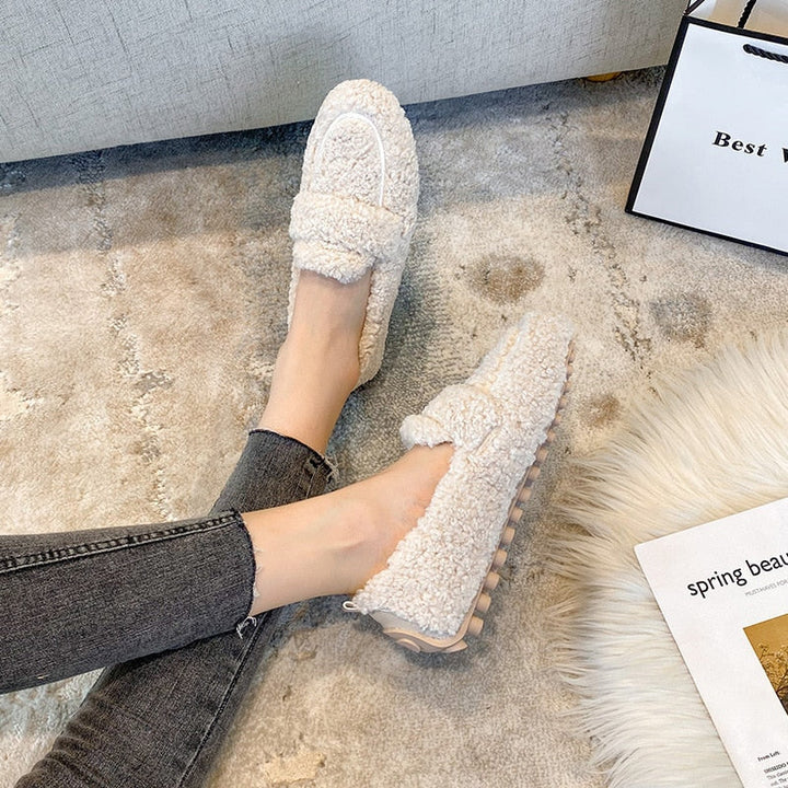 Een paar zachte damespantoffels van pluche, perfect voor comfortabele avonden en relaxen in huis.