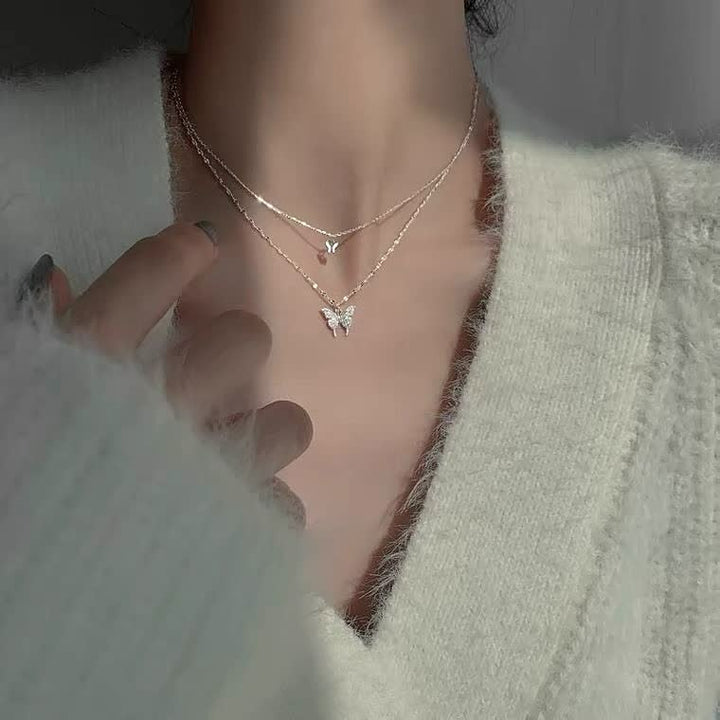 Gedetailleerde weergave van de zilverkleurige vlinder hanger aan de damesketting.