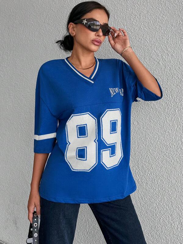 Model draagt zwart oversized dames honkbalshirt. Comfortabel voor dagelijks casual gebruik. Stijlvol.