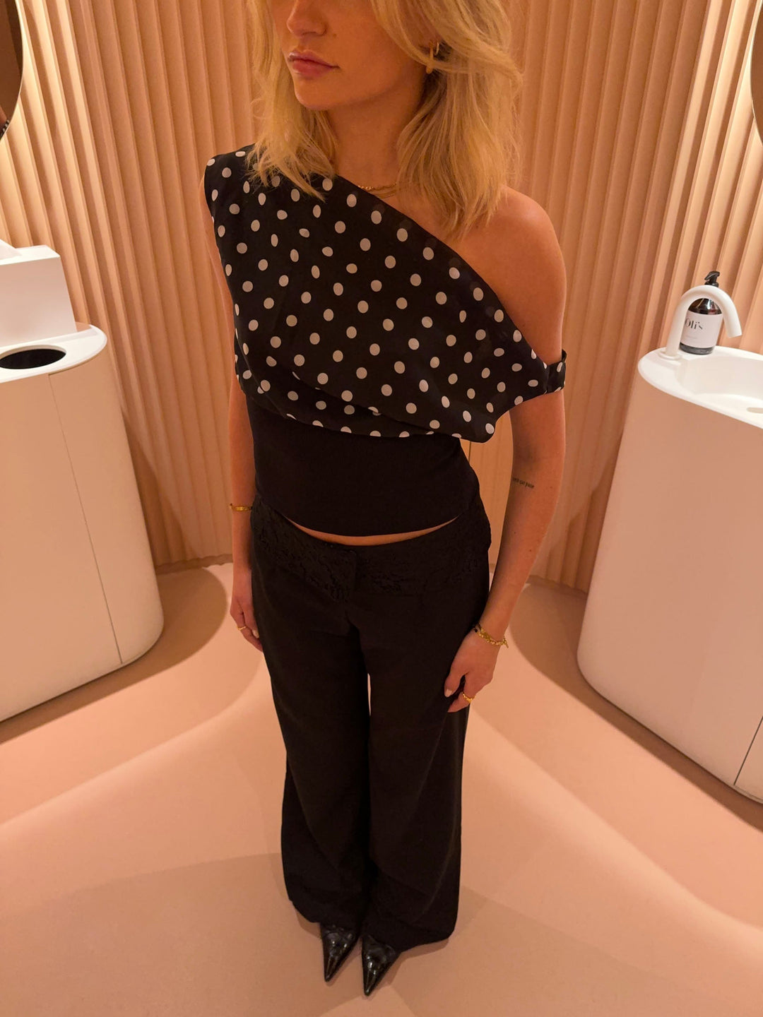 "Zwart-witte polkadot dames top met verstelbare striksluiting voor elegante pasvorm, luchtige stof en vintage flair."
