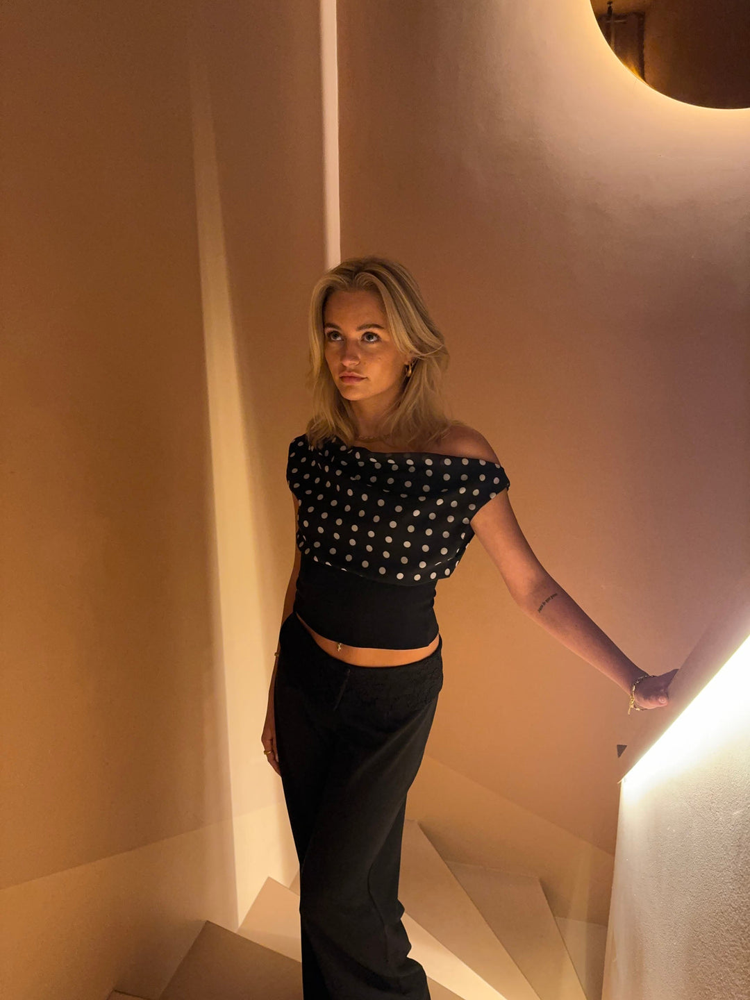 "Zwart-witte polkadot dames top met verstelbare striksluiting voor elegante pasvorm, luchtige stof en vintage flair."