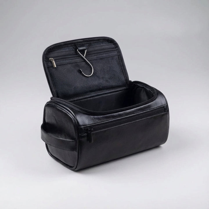 Compacte unisex reistoilettas, zwart, naast reisbagage. Handig voor badkamerartikelen onderweg.