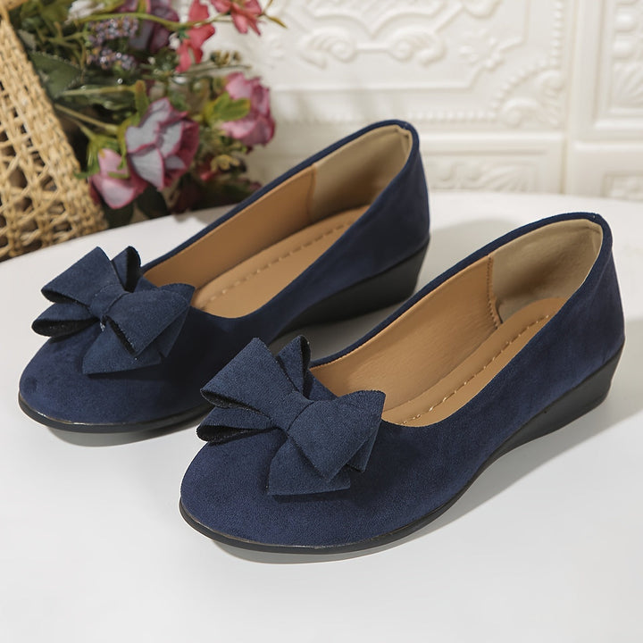 Grijze zomerse ballerina's met sleehak en strik, perfect voor een casual look.