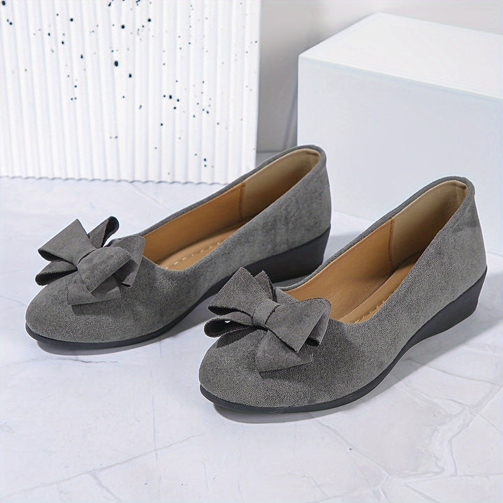 Casual grijze damesschoenen: ballerina's met sleehak en charmant strikdetail.