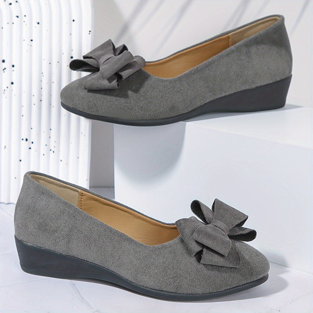 Blauwe slip-on ballerina's, comfortabele sleehak met strik, ideaal voor de zomer.