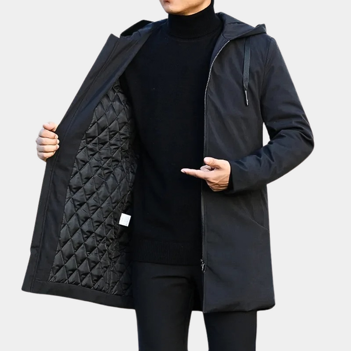 Zwarte heren longline jas met capuchon en ritssluiting, ideaal voor winter en tussenseizoen. Stijlvolle bovenkleding.