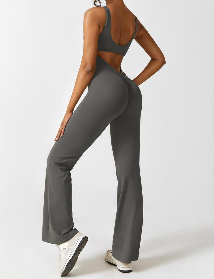 Roze lange jumpsuit met V-hals, uitlopende pijpen en open rug, ideale outfit voor een zomerse bruiloft.